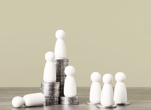 White wooden pegs positioned above stacks of silver coins