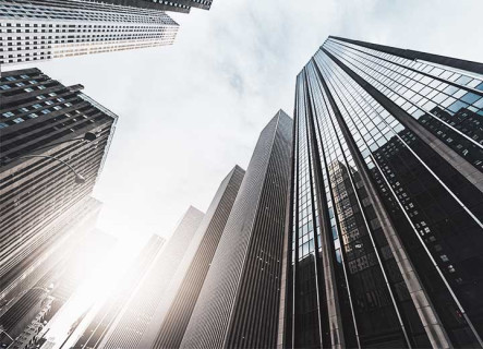 Visão inferior de vários edifícios, um ao lado do outro em uma rua extensa